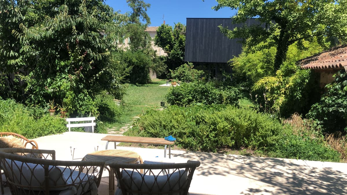 La terrasse du jardin, table et chaises à l'ombre, la Fabrique au fond